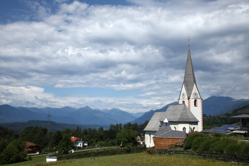 Dorfkirche vor bergiger Kulisse.