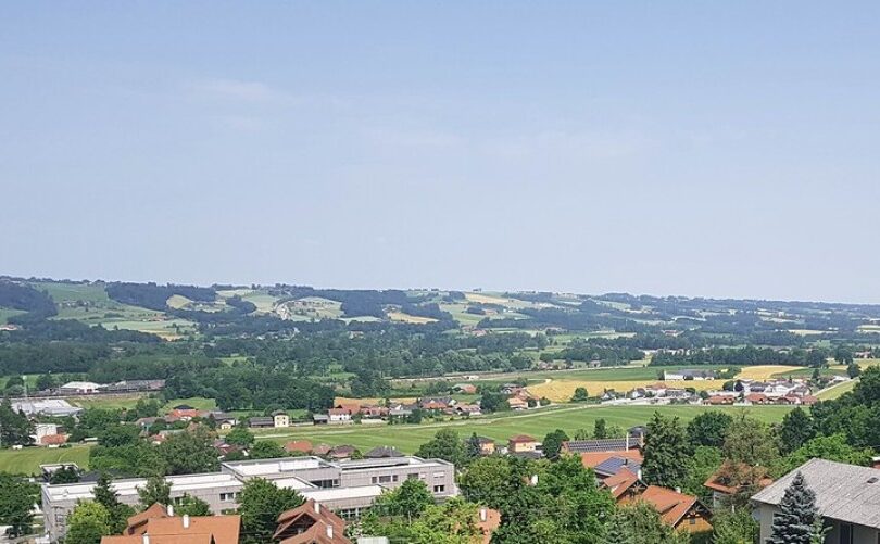 Weite Hügellandschaft mit kleinen Dörfern und Feldern