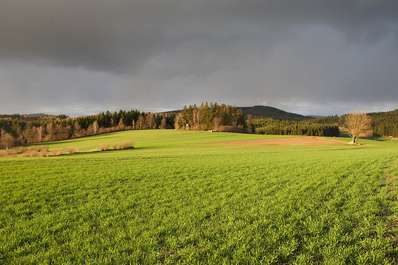 Dunkle Wolken über Hügellandschaft.