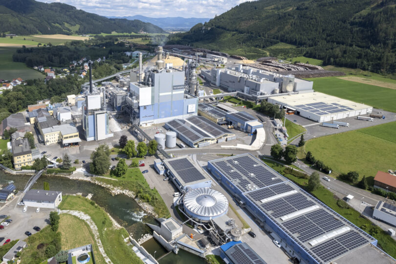 Luftaufnahme einer Industrieanlage mit mehreren Gebäuden und Solaranlagen auf den Dächern.