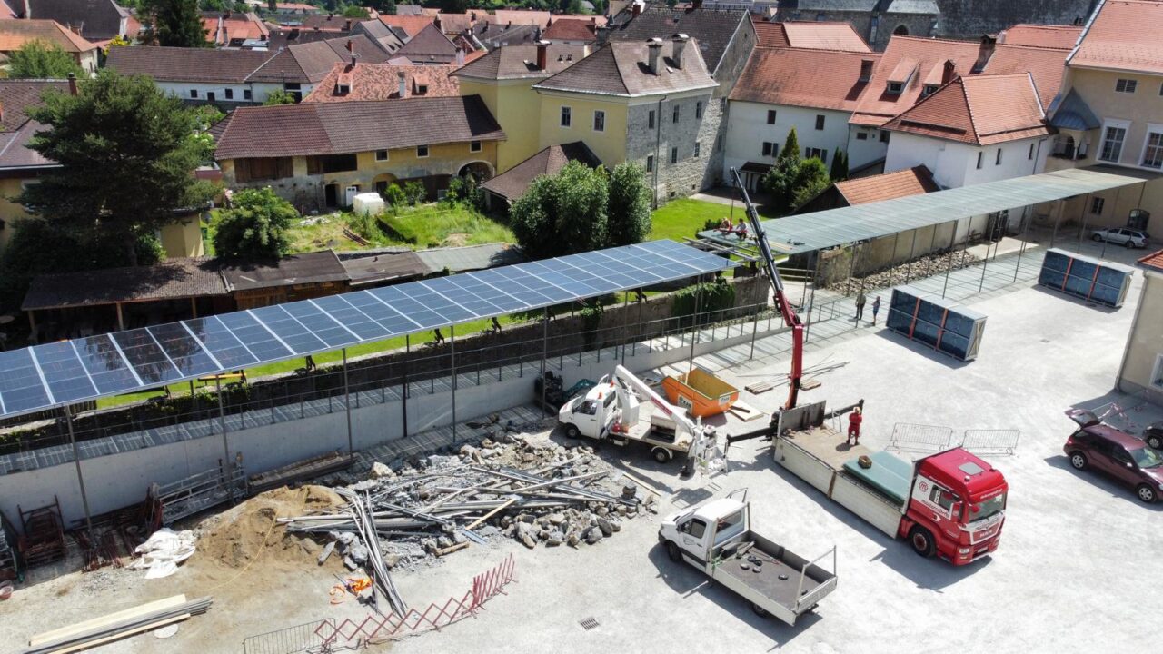 Luftaufnahme einer Baustelle mit Sonnenkollektoren und Baufahrzeugen.