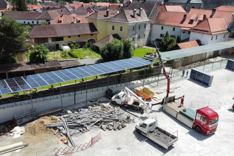 Luftaufnahme einer Baustelle mit Sonnenkollektoren und Baufahrzeugen.