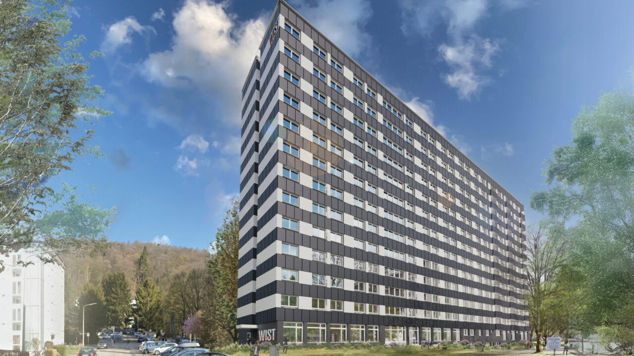 Modernes Hochhaus mit Solaranlagen unter einem blauen Himmel mit Wolken.